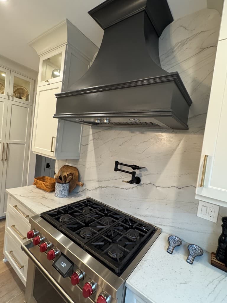 Original close vertical phone photo of a kitchen range and hood